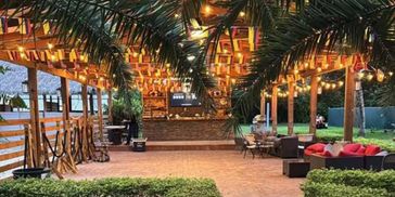Cozy outdoor lounge area with warm string lights and greenery.