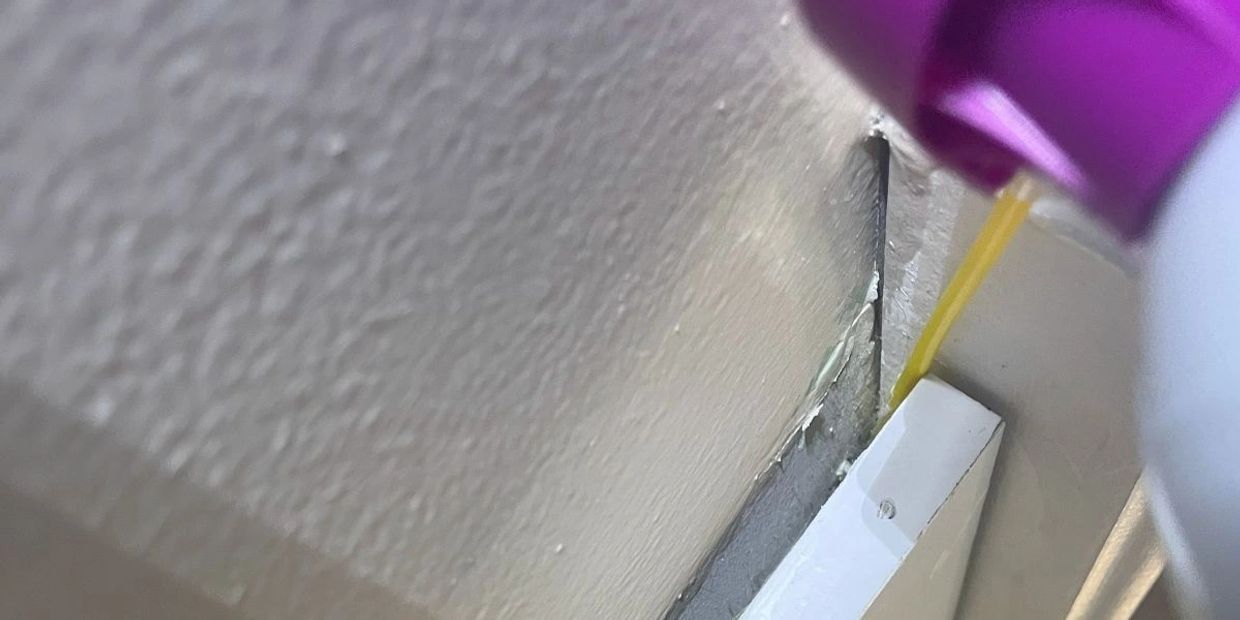 Applying oil sealer to a corner gap.