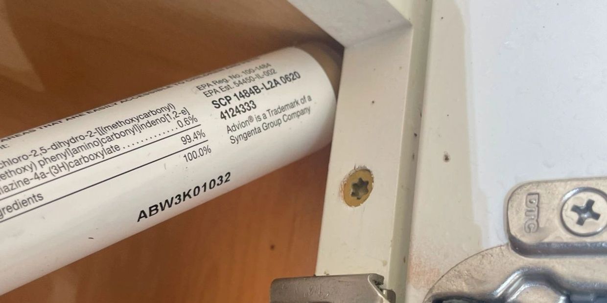 Close-up of a label with chemical information and a hinge.