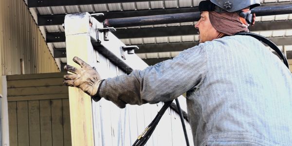 Worker handling large insulated panel outdoors.