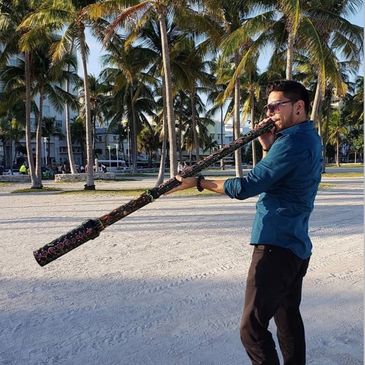 man standing on the seashore with a stick in his hands
