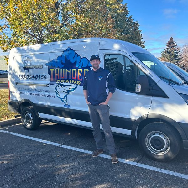 Photo of the owner John in front of the service truck in a parking lot near Zimmerman Minnesota