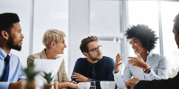 Diverse team engaged in a lively business meeting in a modern office.