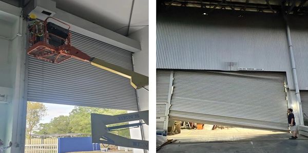 A large industrial door being repaired using a boom lift.