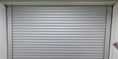 Closed metal roller shutter door in a commercial or garage setting.