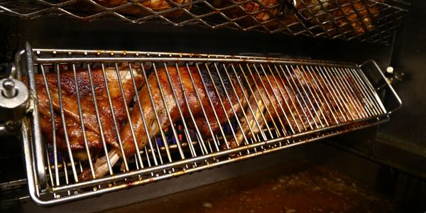 Food roasting on a grill inside an oven.