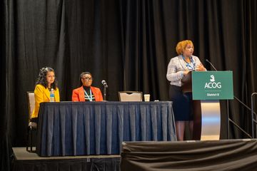 A panel of presenters for a conference of ACOG