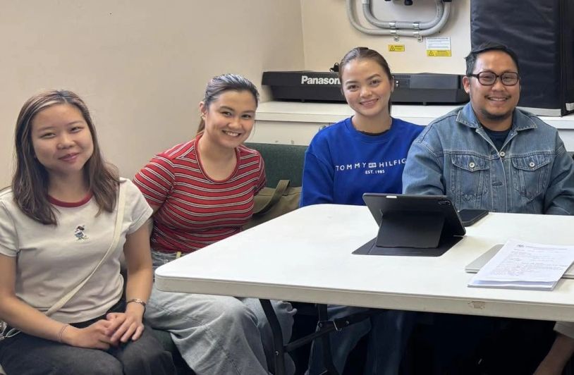 Four people sitting around a table smiling.