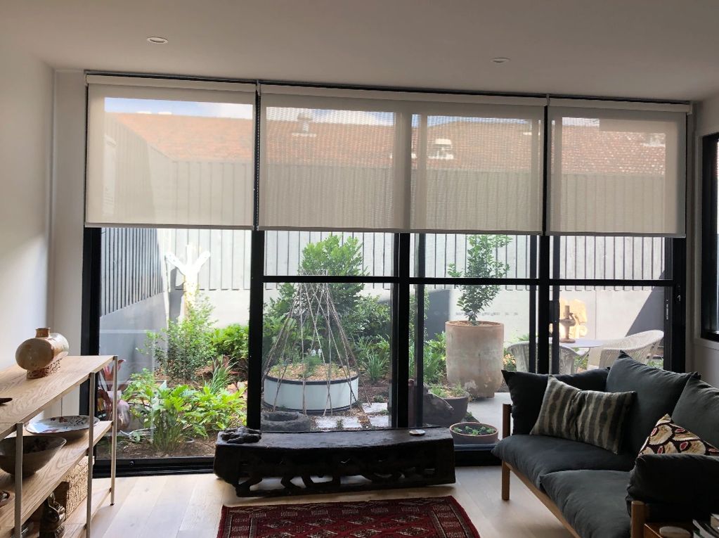 Living room with large windows and a garden view.