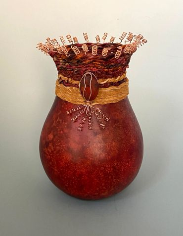 Decorative vase with copper wire accents and a textured band.