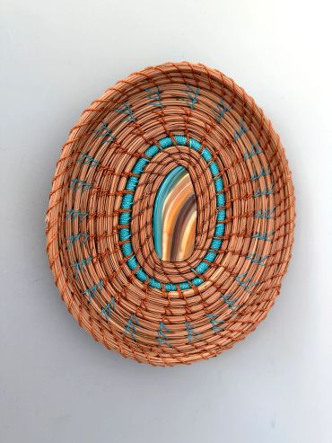 Woven basket with embedded stone art.