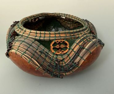 Artistic woven basket with natural materials and intricate design.