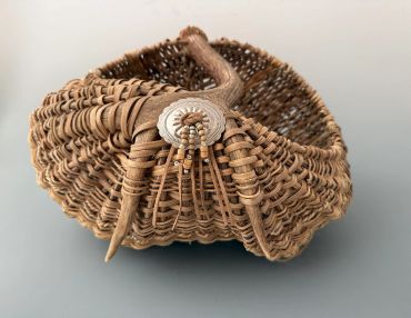 Woven basket with a button and antler detail.