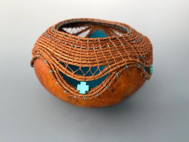 Decorative pottery with woven net and turquoise details.