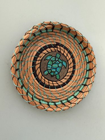 Woven basket with a turtle design.