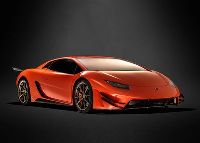 Sleek orange sports car with aerodynamic design on black background.