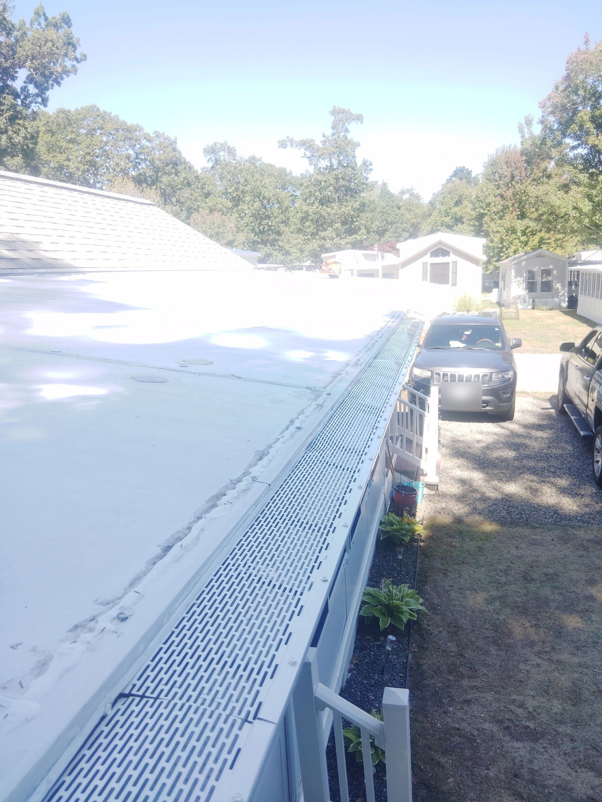 Gutter guard installed along a roof edge to help prevent clogs