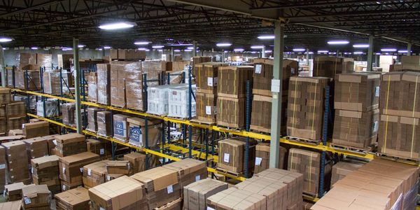 a warehouse with corrugated boxes stacked in pallets, flat, ready to be shipped out for distribution