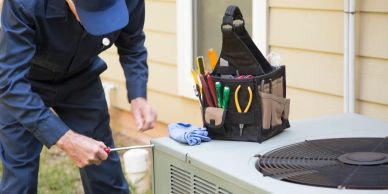 Technician inspecting an air conditioner outdoors.