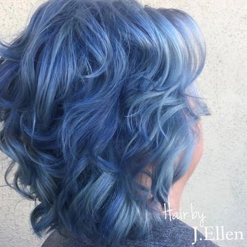 Curly hair dyed in vibrant shades of blue with soft waves.