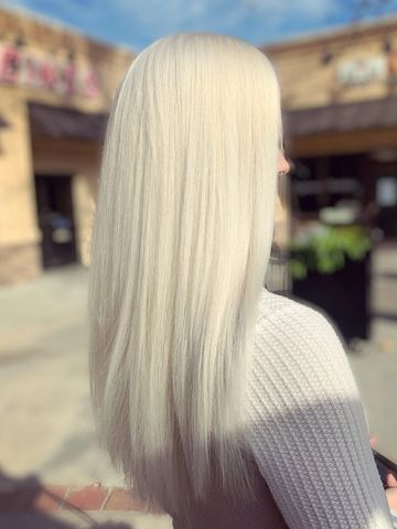 Woman with long, straight platinum blonde hair outdoors.