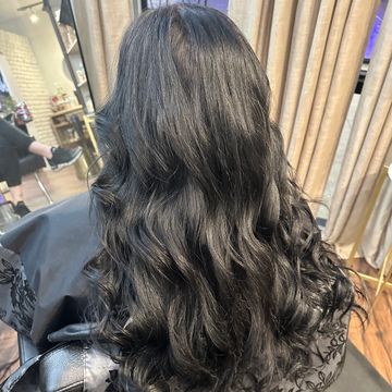 Long, wavy black hair styled in a salon.