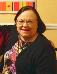 Smiling woman with glasses posing indoors.