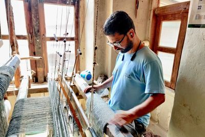 Man working on a traditional weaving loom.