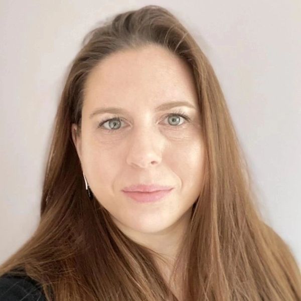 Close-up portrait of a woman with long brown hair and light eyes.