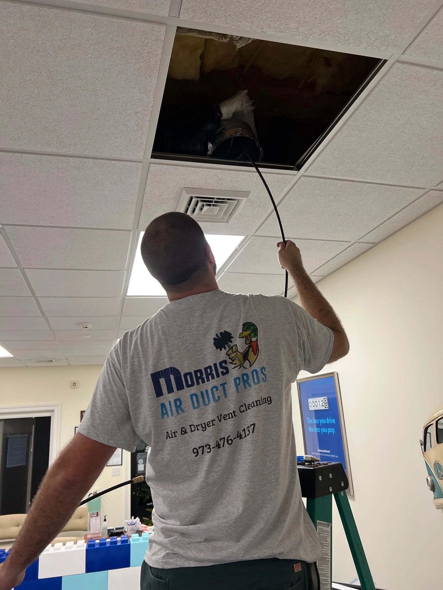 Man wearing T shirt with writing Morris Air Duct Pros