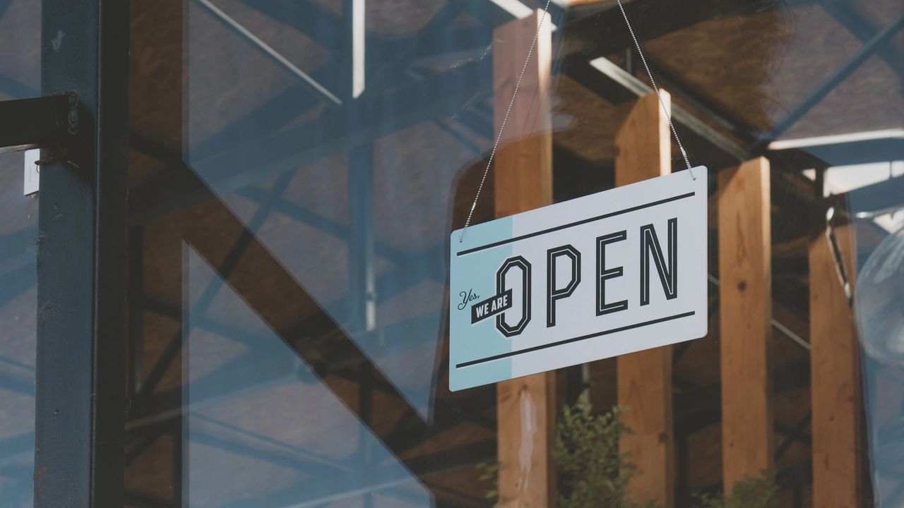 open sign in window of small business