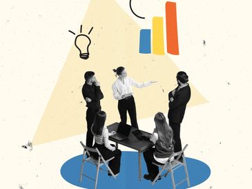 Team discussing ideas and strategies around a table with digital devices.