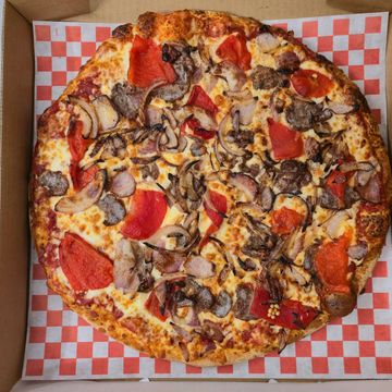 A freshly baked pizza topped with Red roasted peppers, caramalized onions and meatball finished with romano 