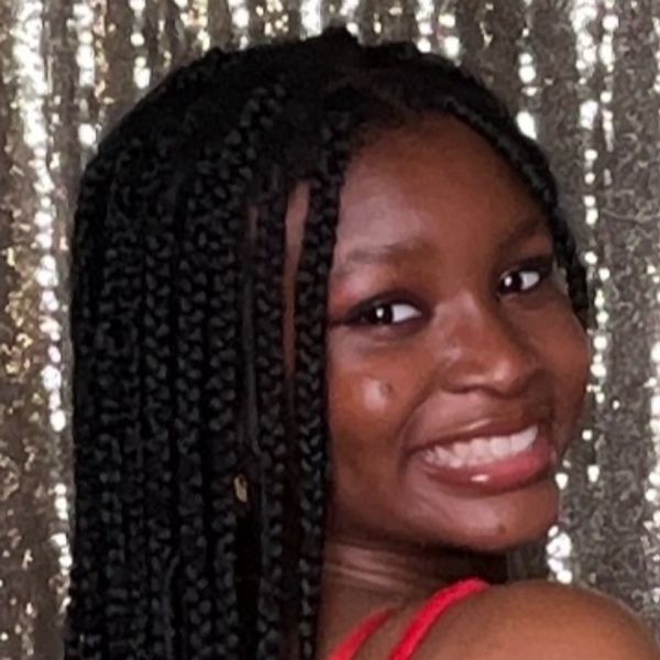 Close-up of a smiling young woman with braided hair.