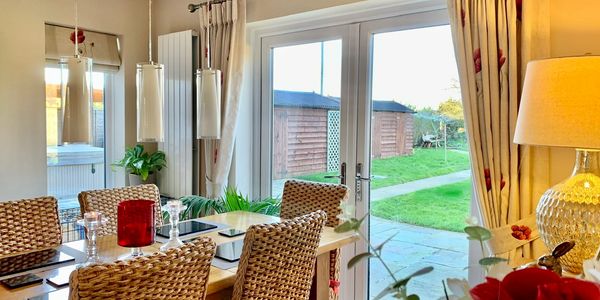 Curtains and a blind in dining room. Natural colour with red poppy detail.
