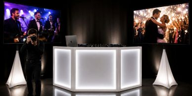 DJ setup with photos on two screens.