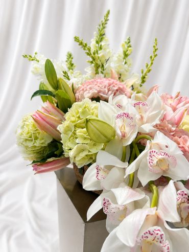 Elegant floral arrangement with white orchids and pink tulips.