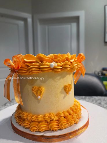 Orange-themed cake with decorative frosting and ribbons.