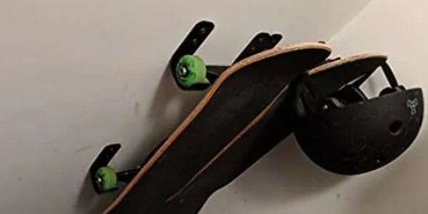 Black hooks hanging skateboard and helmet on the ceiling wall