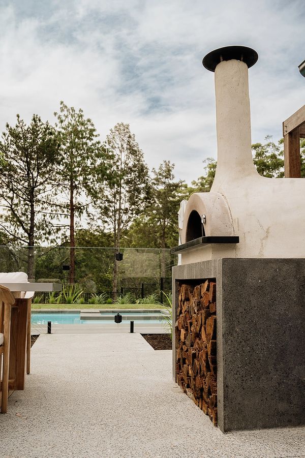 Wood-fired pizza oven beside the pool at Berry Luxury Barn House