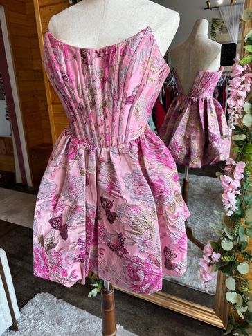 Pink floral strapless dress on a mannequin.