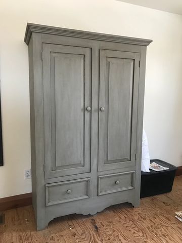 Gray wooden cabinet with two doors and two drawers.