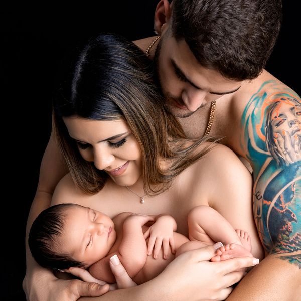 Family photo of dad and mom holding their newborn baby. 