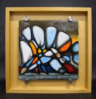 Abstract colorful stained glass art in a wooden frame.