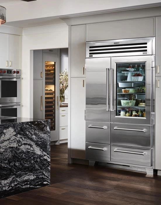 Modern kitchen with stainless steel appliances and a black marble island.