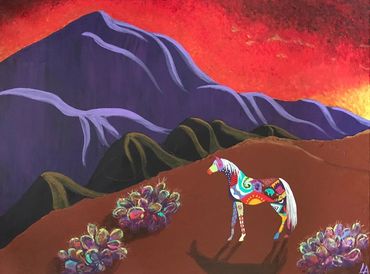 Painted horse stands in the Placitas hills gazing at the Sandia Range. A vivid sunrise breaks a new 