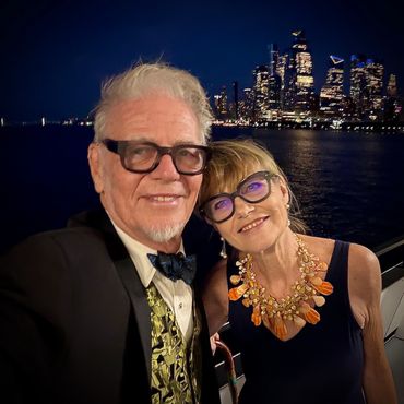 Older couple enjoying a night out with city skyline background.