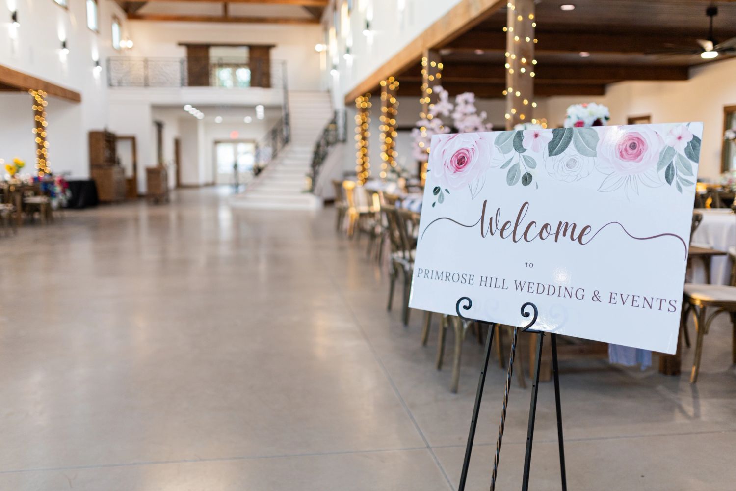 Interior of the reception barn with welcome sign and string lights