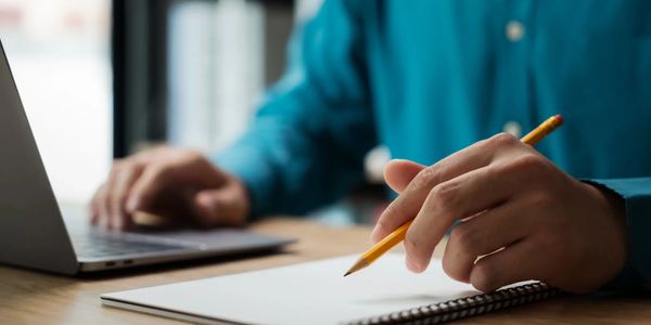 Writing at desk with notes and books
