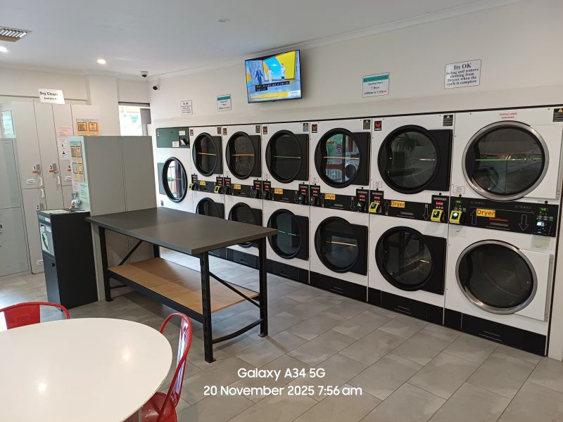 Rows of washers and gas dryers inside the laundrette
